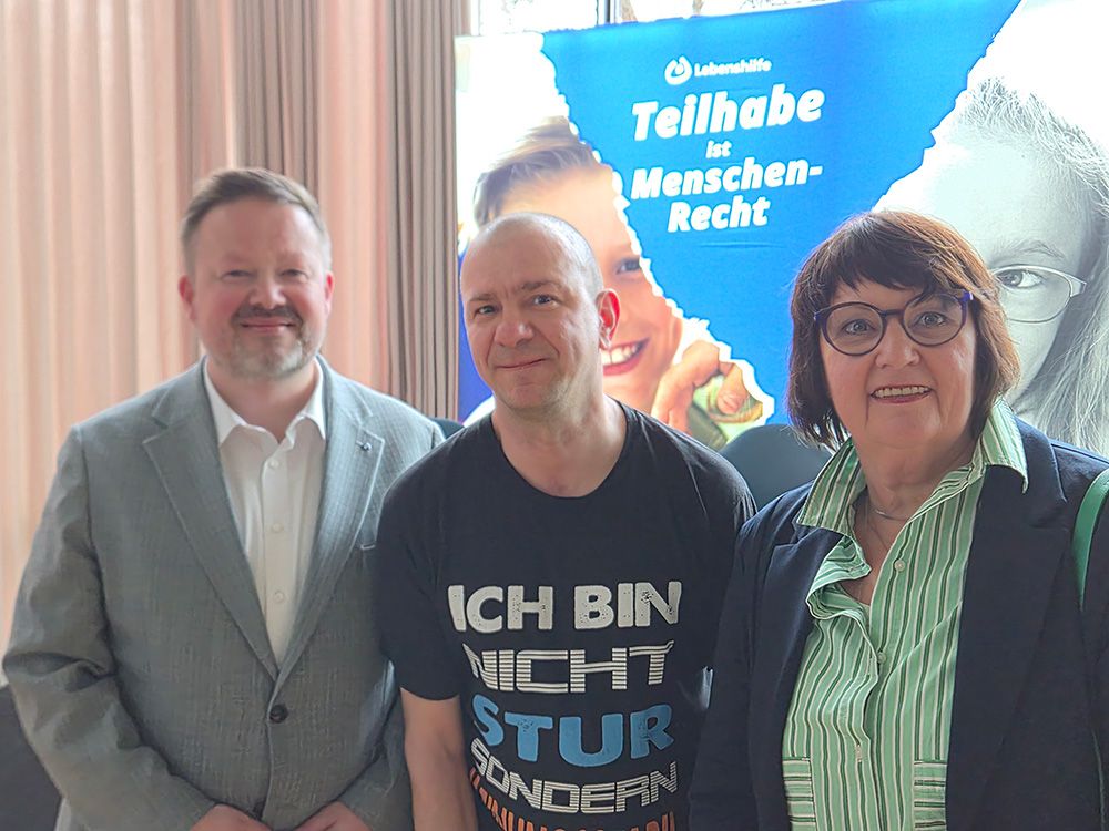 Landesgeschäftsführer Frank Steinsiek, Selbstvertreter & Landes- und Bundesvorstandsmitglied Dirk Michalek und stellvertretende Landesvorsitzende Gaby Bökenkröger (v.l.) vor dem Kampagnenlogo „Teilhabe ist Menschenrecht“ der Bundesvereinigung Lebenshilfe e.V.